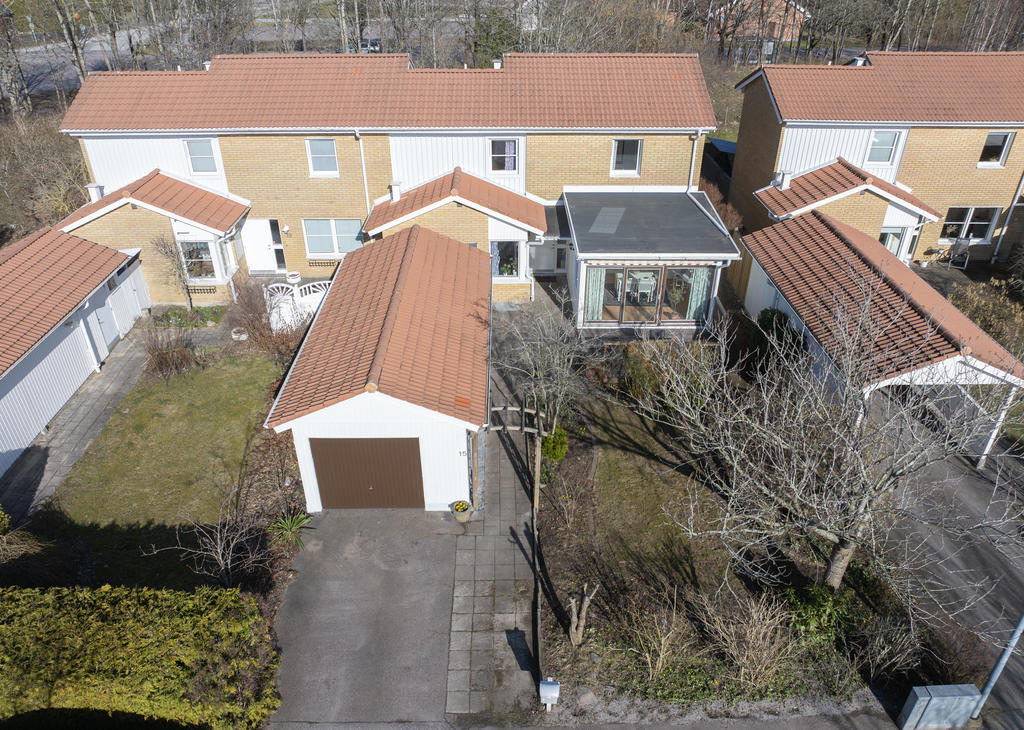 Framsidan med garage och uterum mot väster.