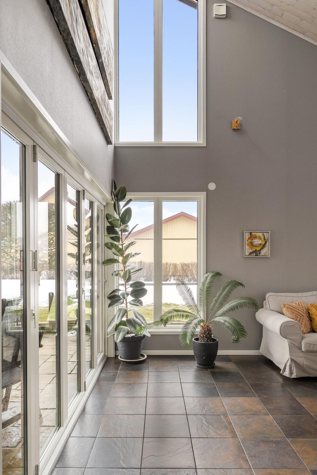 Vardagsrummet har en otrolig rymd med det sneda taket. Stora fönster ger rummet både ljus och rymd.