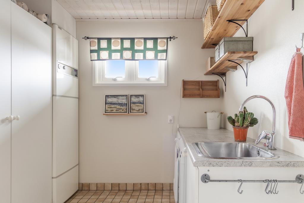 Tvättstuga med både arbetsytor och förvaring. Här finns husets panna.