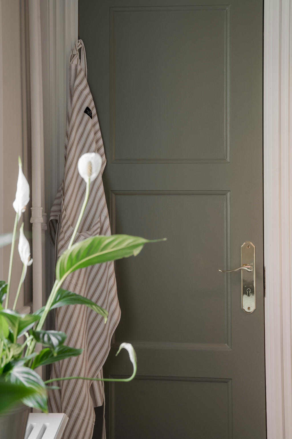 Bakom den gröna dörren i köket rymmer sig bostadens tvättstuga