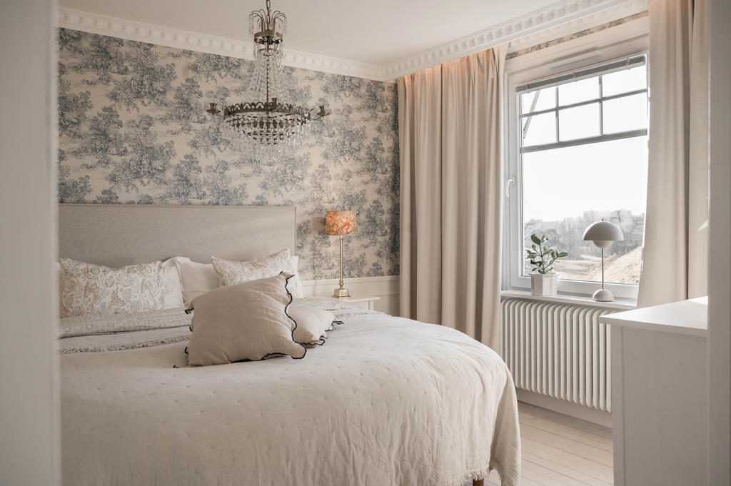 Välkommen till sovrummet - genom vackra dubbeldörrar kommer du in det franskinspirerade rummet