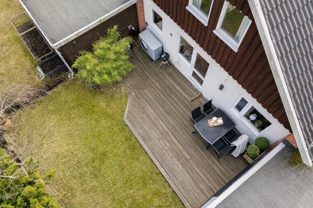 Direktaccess från kök till trädäckad altan och trädgård med plana, lekvänliga gräsytor