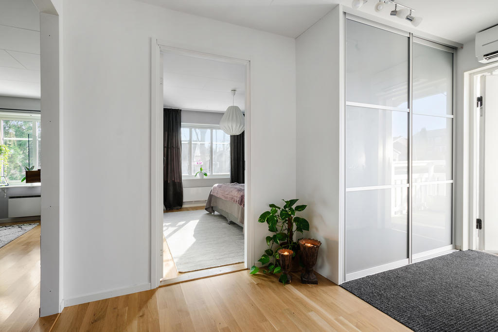 Entréparti med rymlig garderob. Glimt mot sovrum och vardagsrum