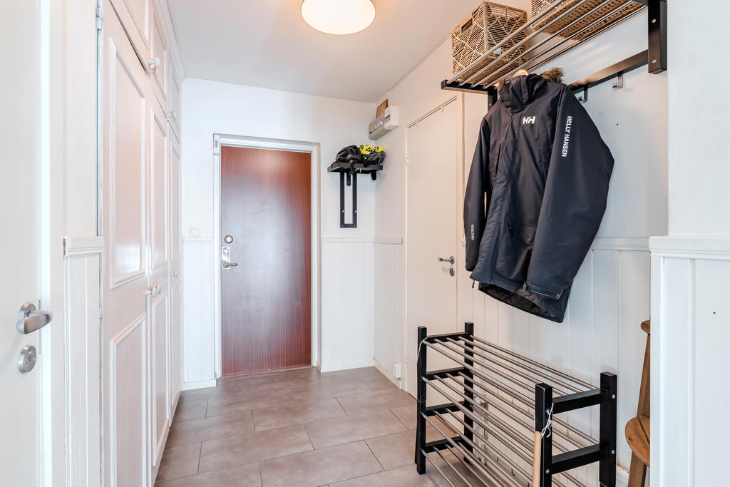 Hallen med flera garderober och hatthylla. Badrummet når du till höger. 