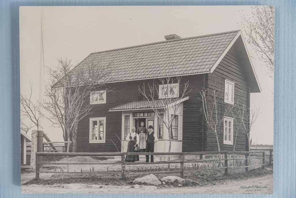 Olters Erik Person och Olters Anna Persdotter och deras mamma framför huseti början på 1900-talet.