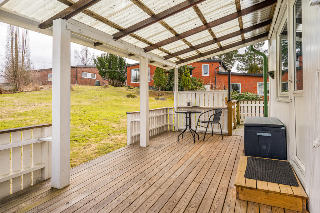 Altan under tak med tillbyggd balkong.