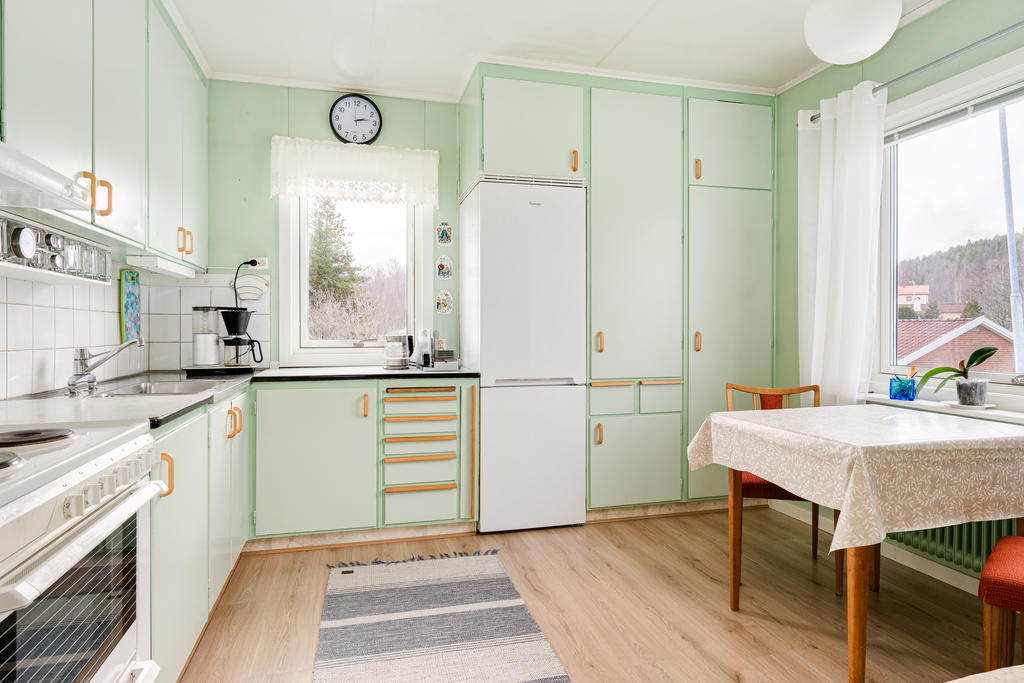 Välskött kök med tidstypiska detaljer bevarade och plats för matbord. 