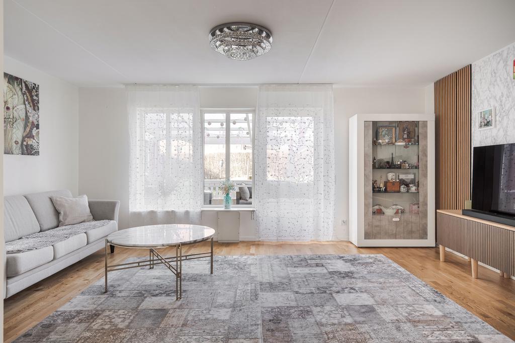 Rymligt vardagsrum med fönster mot uteplats och trädgård