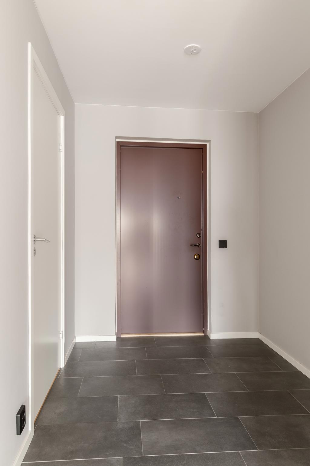 Entré med ljusa ytskikt och säkerhetsdörr.