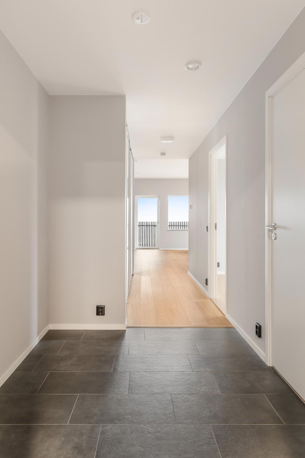 Hall med siktlinje mot bostadens sociala ytor.