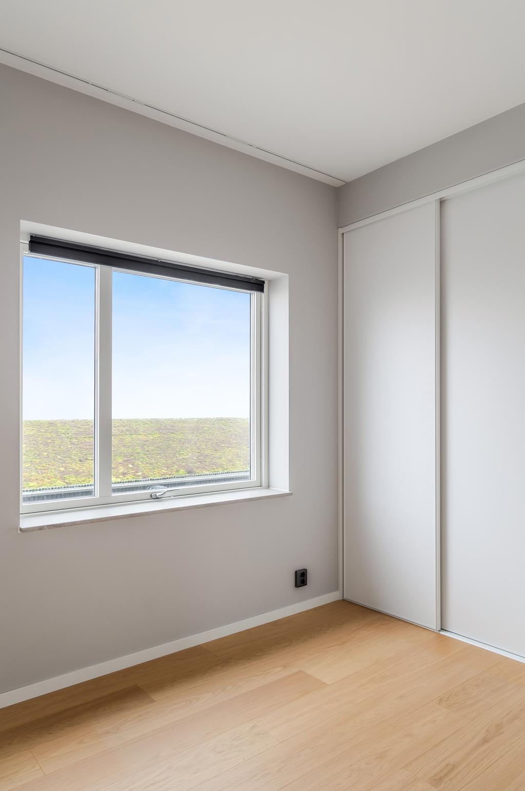 Sovrum med fint ljusinsläpp och utsikt mot omgivningen.