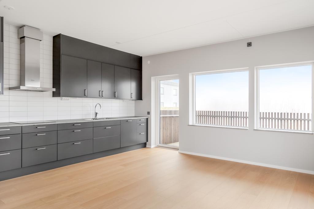 Kök med plats för matgrupp intill fönster och balkongdörr.