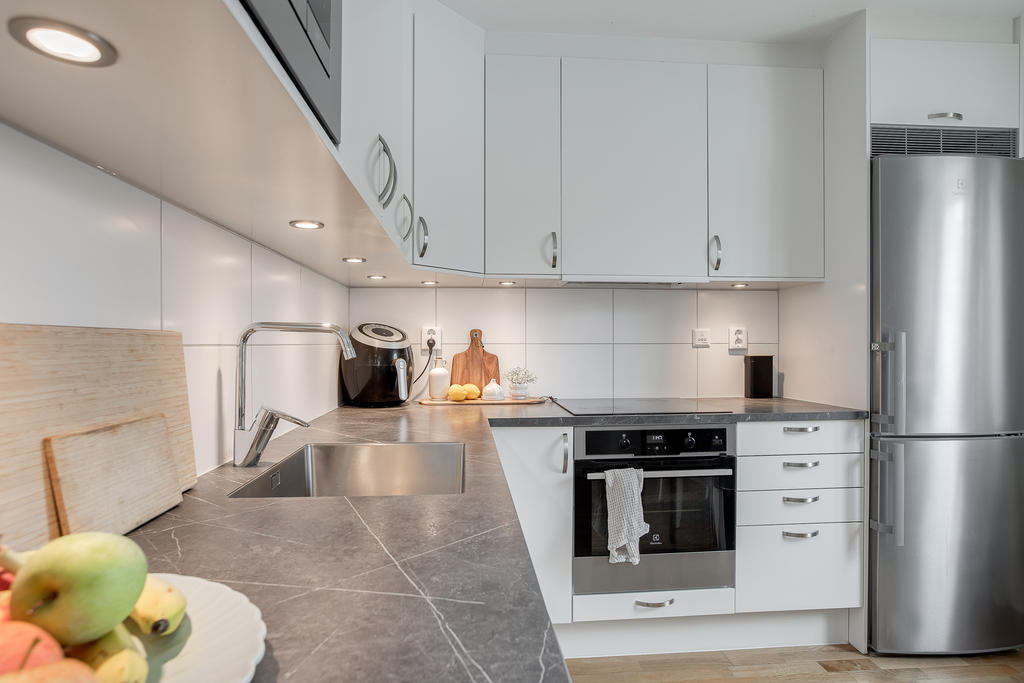 Stilrent kök med inbyggda vitvaror i rostfritt stål