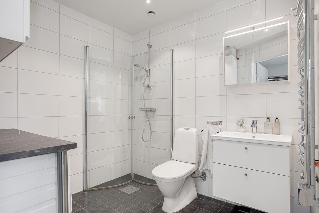 Badrum med duschhörna och kombinerad tvättstuga