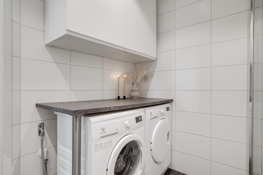 Badrum med kombinera tvättstuga (förvaringsskåp, torktumlare och tvättmaskin)