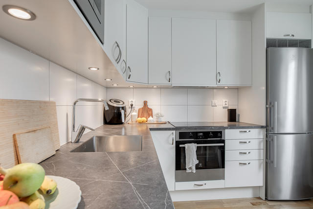 Stilrent kök med inbyggda vitvaror i rostfritt stål