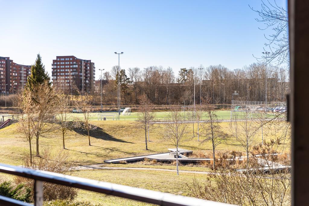 Fritt läge med utsikt ner mot grönområde och fotbollsplaner. 