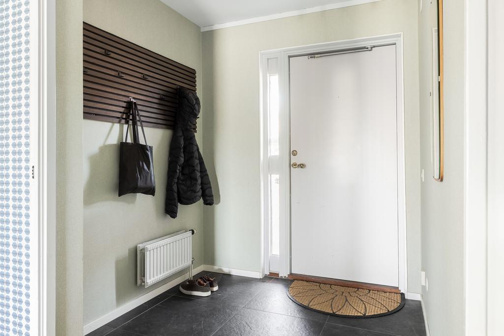 Välkomnande entré med stora klinkerplattor. 