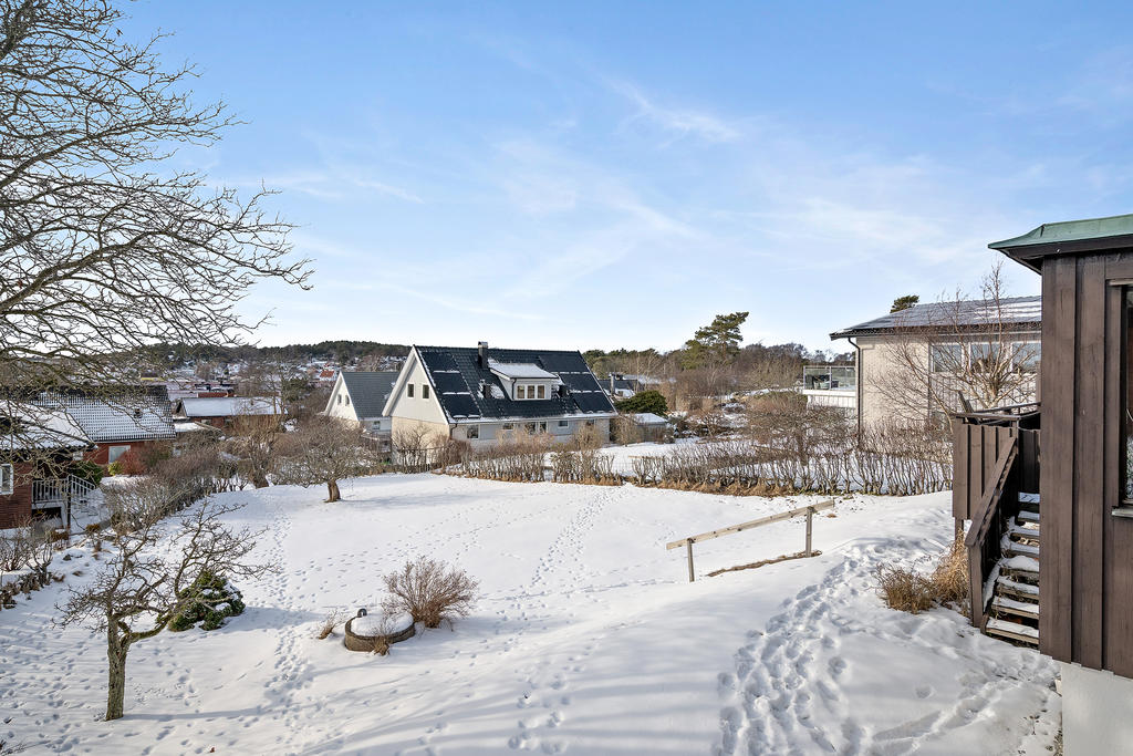 Till vänster om huset finns en parkeringsplats med plats för flertalet bilar