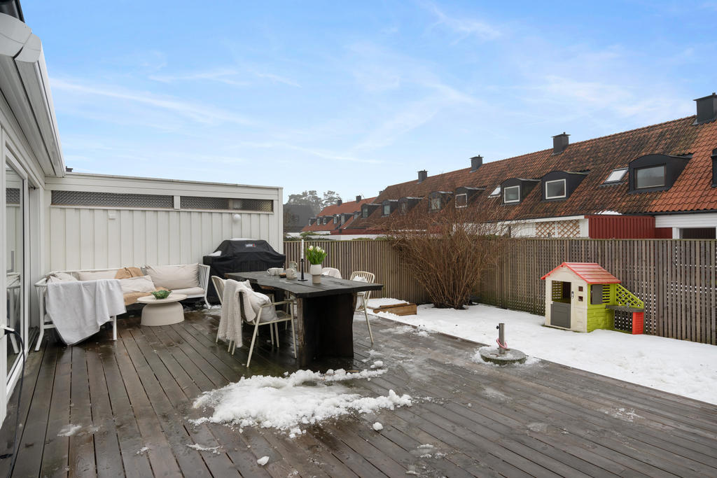 På den rymliga altanen samlas vänner och familj för långa middagar i kvällssolen, medan barnen springer fritt över gräsmattan.