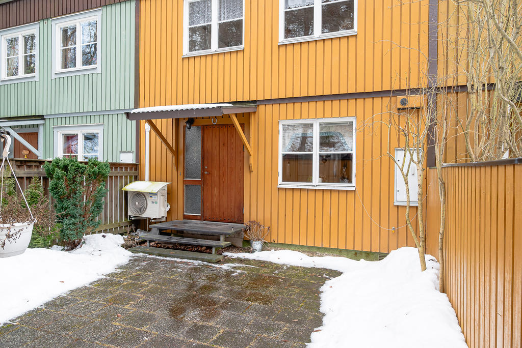 Entrésidan med stenlagd uteplats.