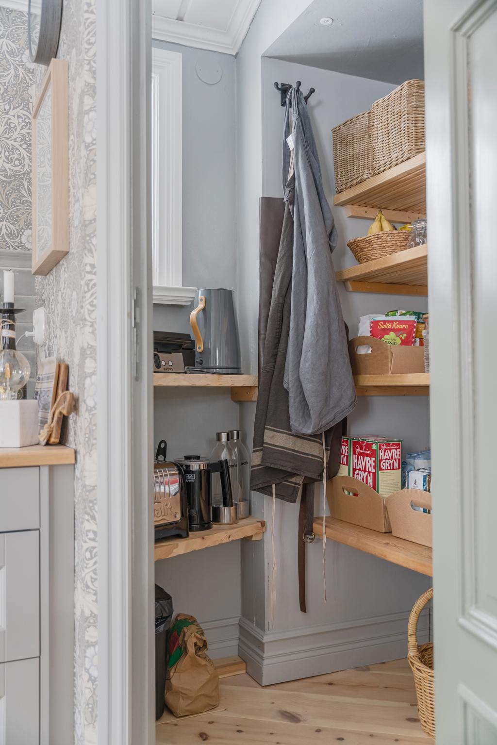 Praktiskt platsbyggt skafferi som erbjuder gott om förvaring.