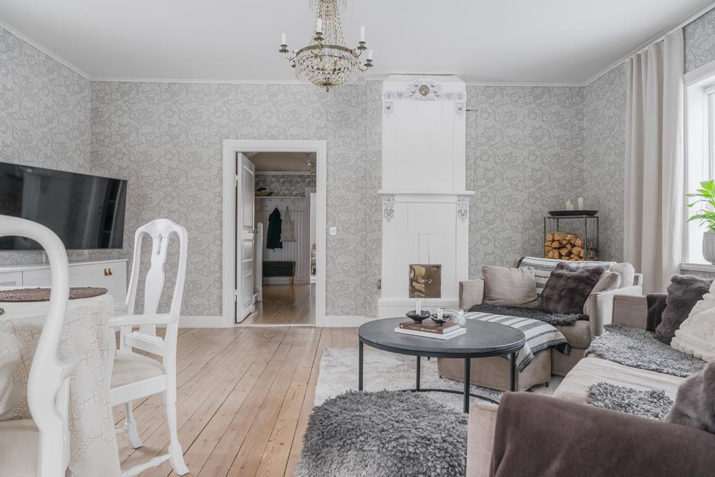 Klassisk vit kakelugn med dekorativa detaljer.