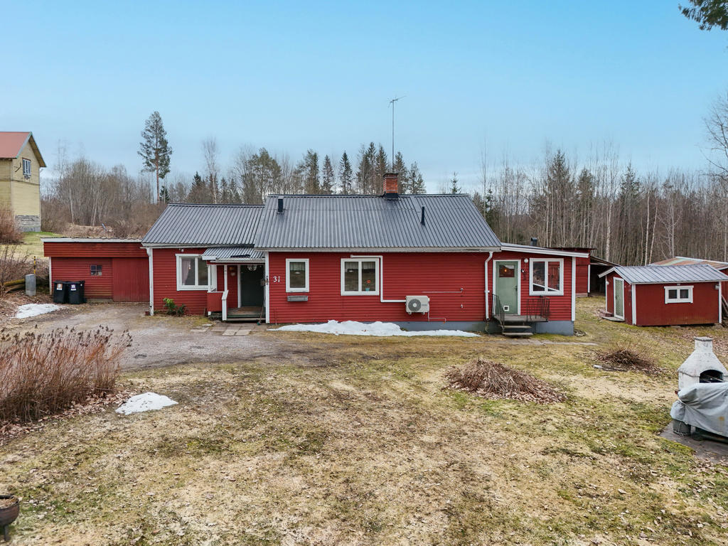 Utbyggt hus med vidbyggt garage. Fasad i väst. 
