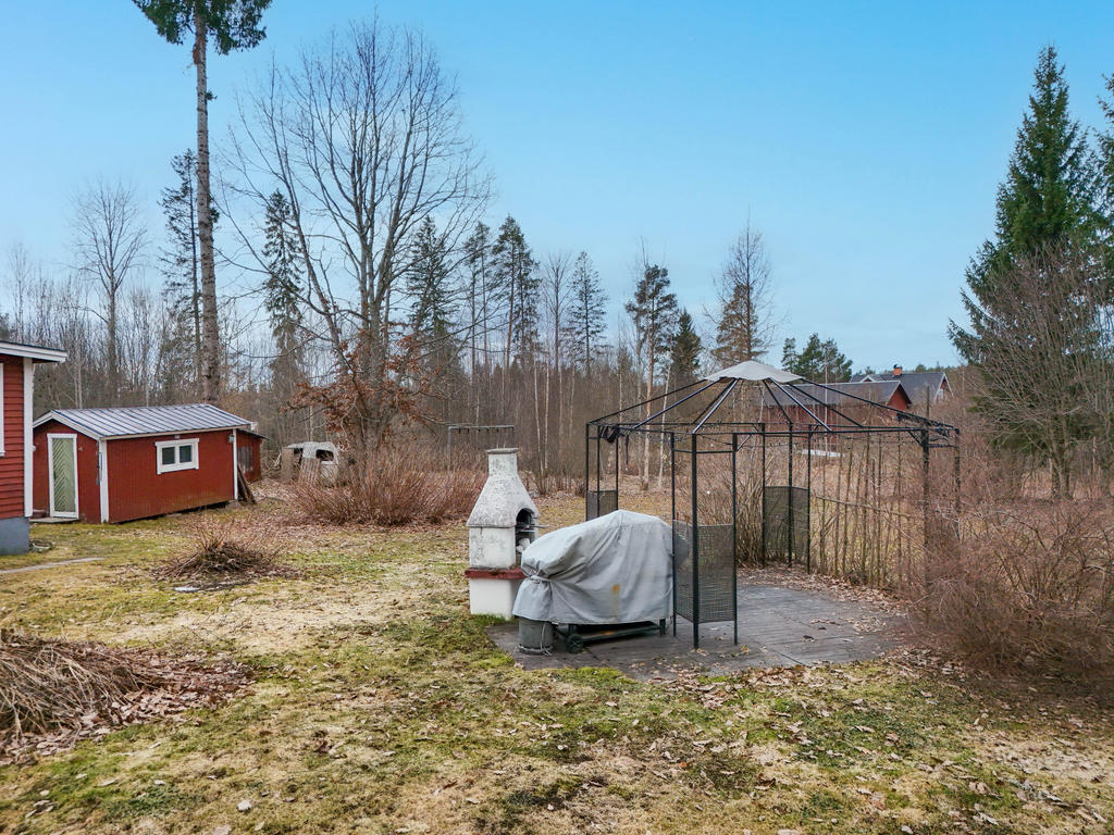 Uteplats med grill på tomten i soligt läge. Med friggebod i bakkant av bilden. 