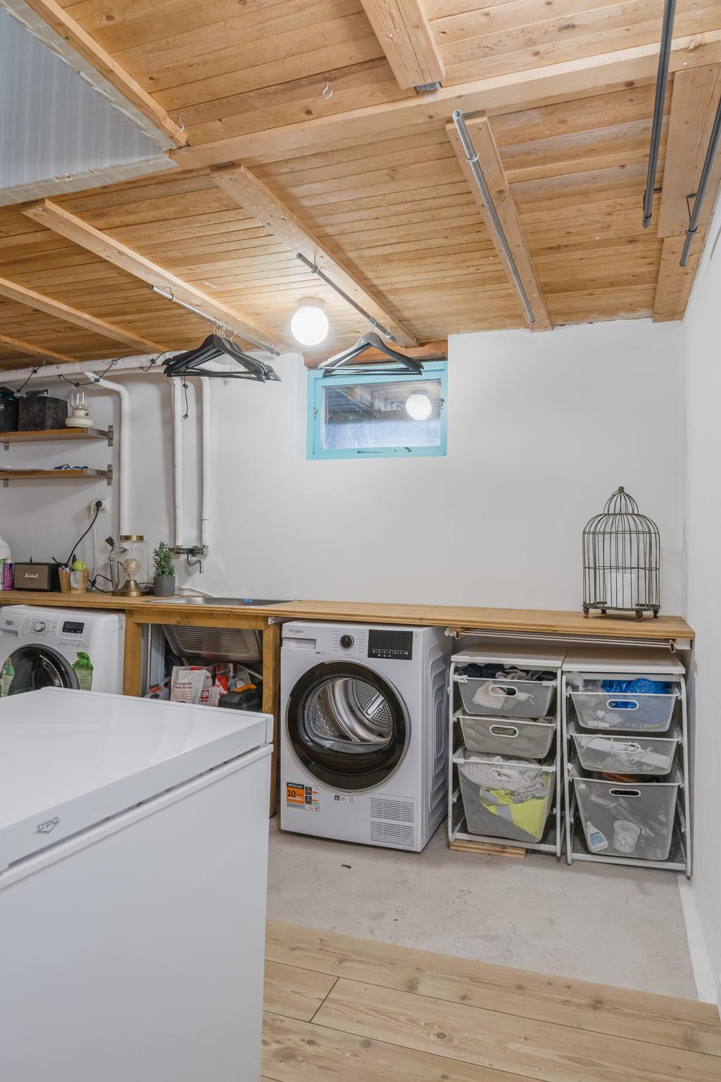 Välkommen ner i källaren till en tvättstuga med tvättmaskin, torktumlare samt förvaringsmöjlighet