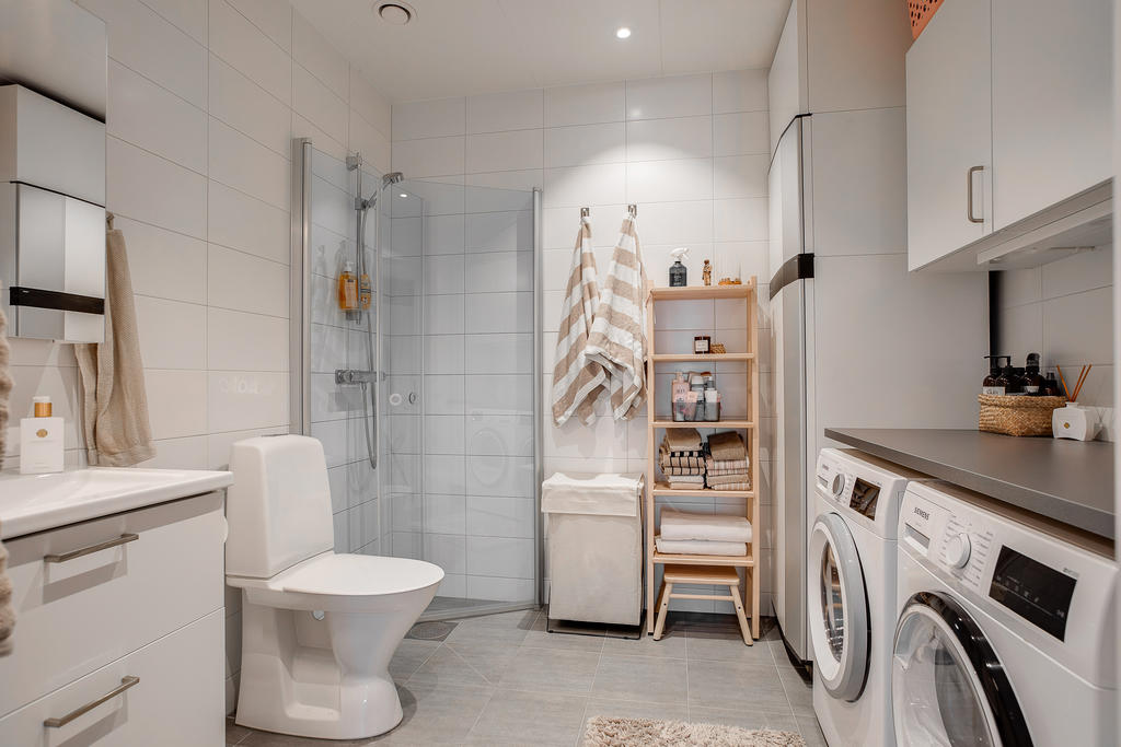 Duschrum med tvättmöjligheter. I hörnet står även Värmpumpen.