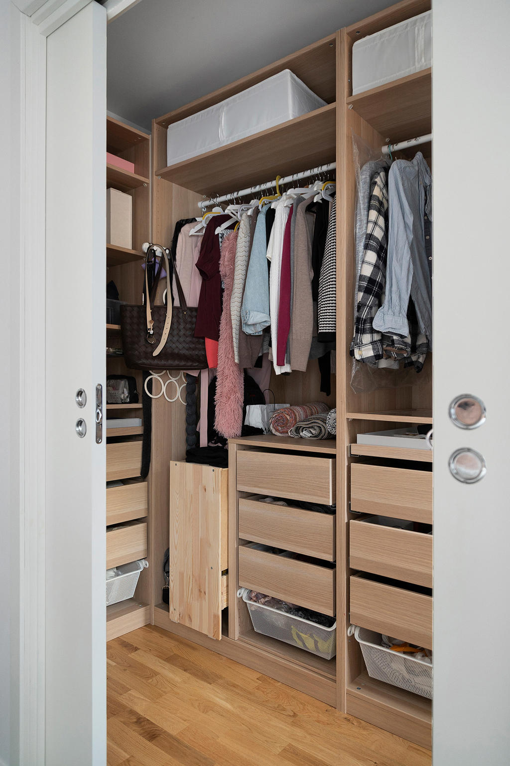 Väl inredd klädkammare bakom skjutdörrar