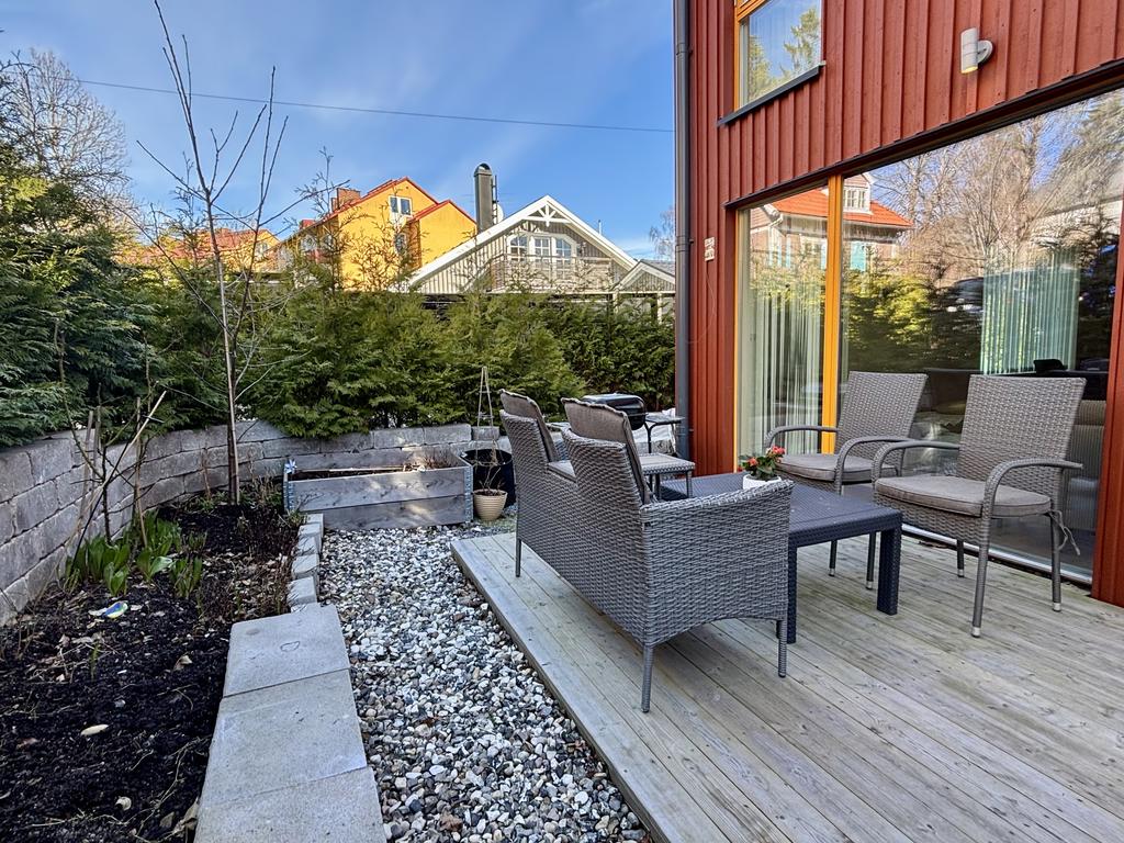 Rabatt med rosor och tulpaner och odlingslåda för kökskryddor