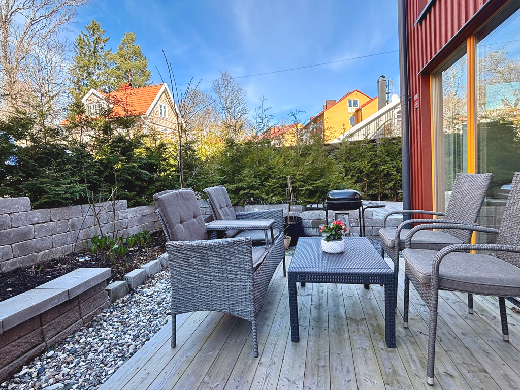 Uteplats inramad av stenmur och Tujor