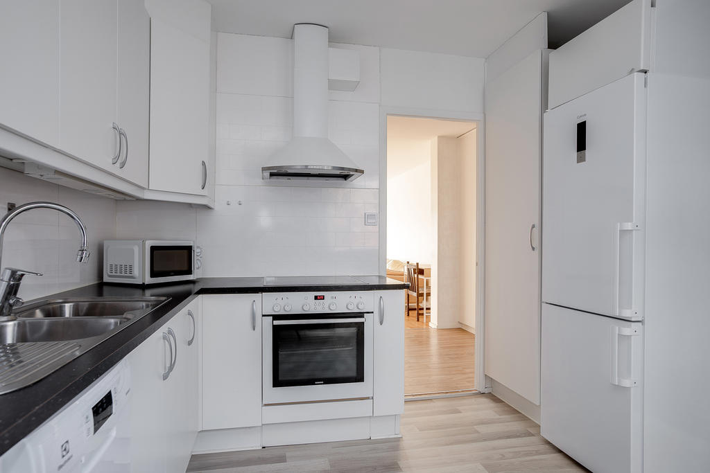 Vit köksinredning med bra förvaringsutrymmen och arbetsyta