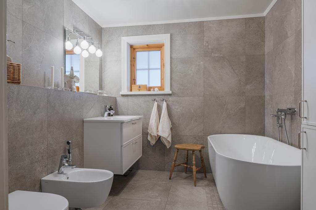 Badrummet är nyrenoverat och lyxigt med stora plattor på väggar och golv. 