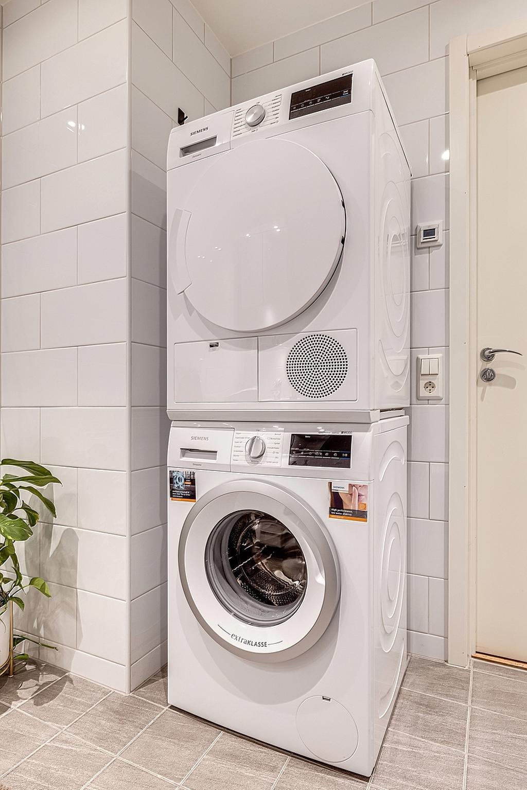 Tvättavdelning med tvättmaskin och torktumlare, praktiskt och bekvämt att ha detta i lägenheten.