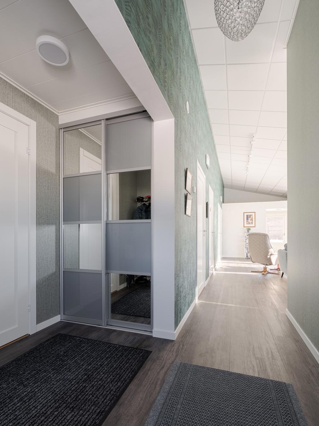 Hall, gång som leder ut till den öppna planlösningen mellan vardagsrum och kök. 