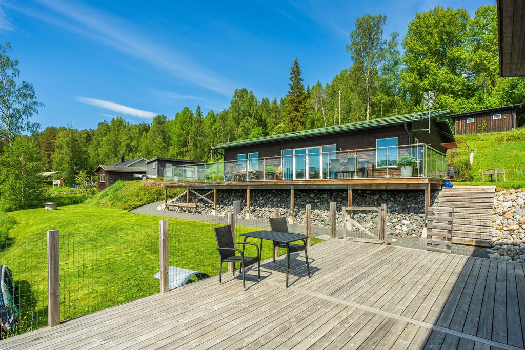 Uteplats framför sjöstuga, i direkt anslutning till bostadshus och uteplats/altan. 