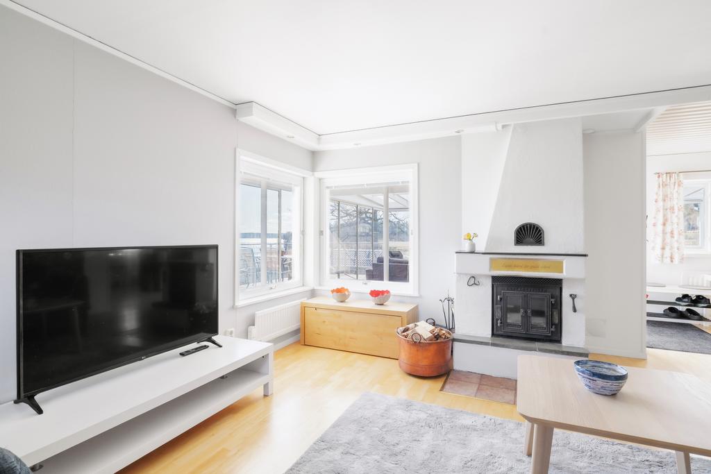 Stort vardagsrum med tapetserade väggar och bokgolv.