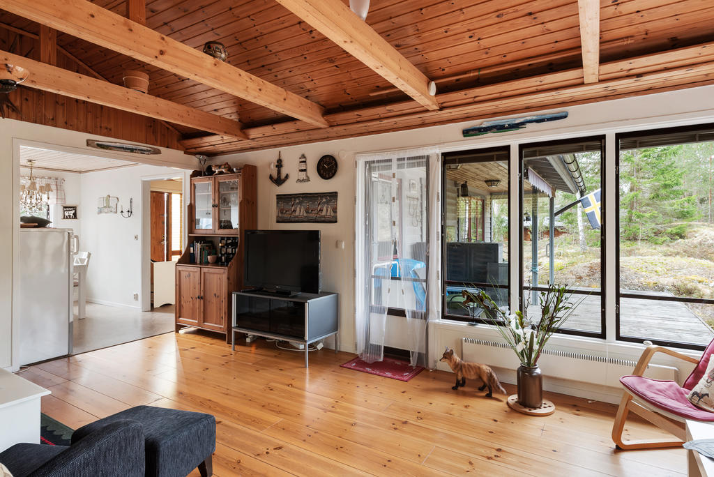 Vardagsrum med öppet till nock och trägolv. Utgång till altanen.