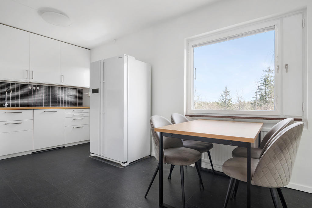 Fräscht renoverat kök med matplats och side-by-side kyl/frys