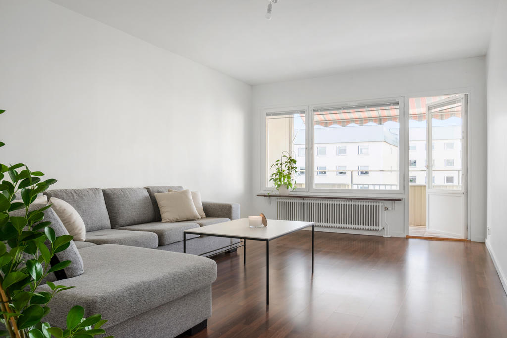 Vardagsrum med utgång till solig balkong