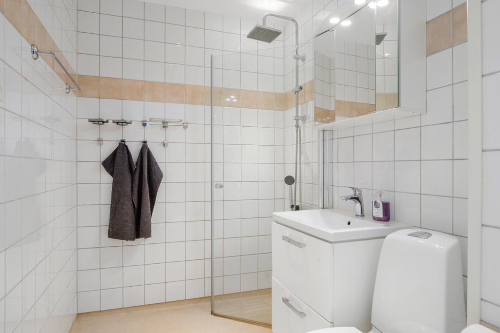 Kaklat badrum med duschplats som kan bytas mot badkar för den som föredrar det. 