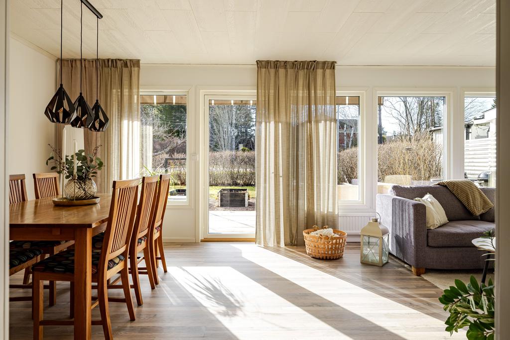Vardagsrum med matplats och soffhörna, samt utgång till baksidan