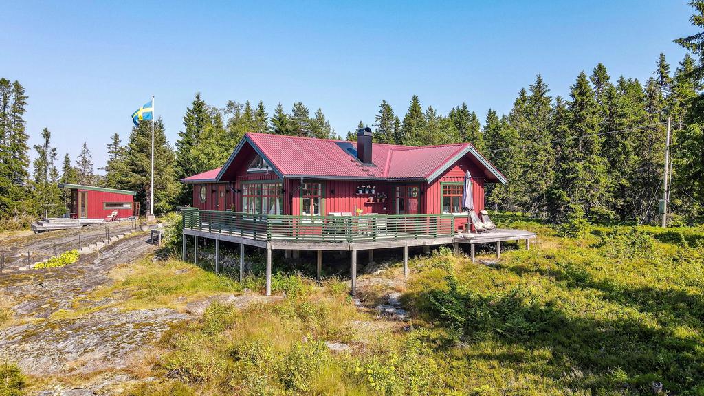 Fritidshuset sett från sydväst. med den stora omfamnande altanen.
