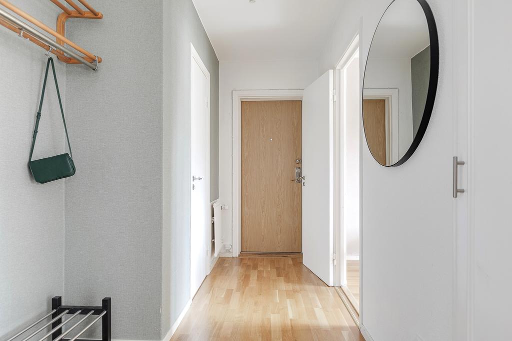 Entré med klädförvaring och dörr in till klädskåp