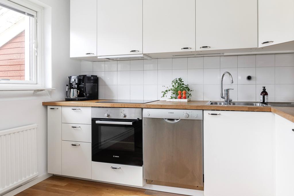 Diskmaskin, spishäll och vacker oljad köksbänk i trä