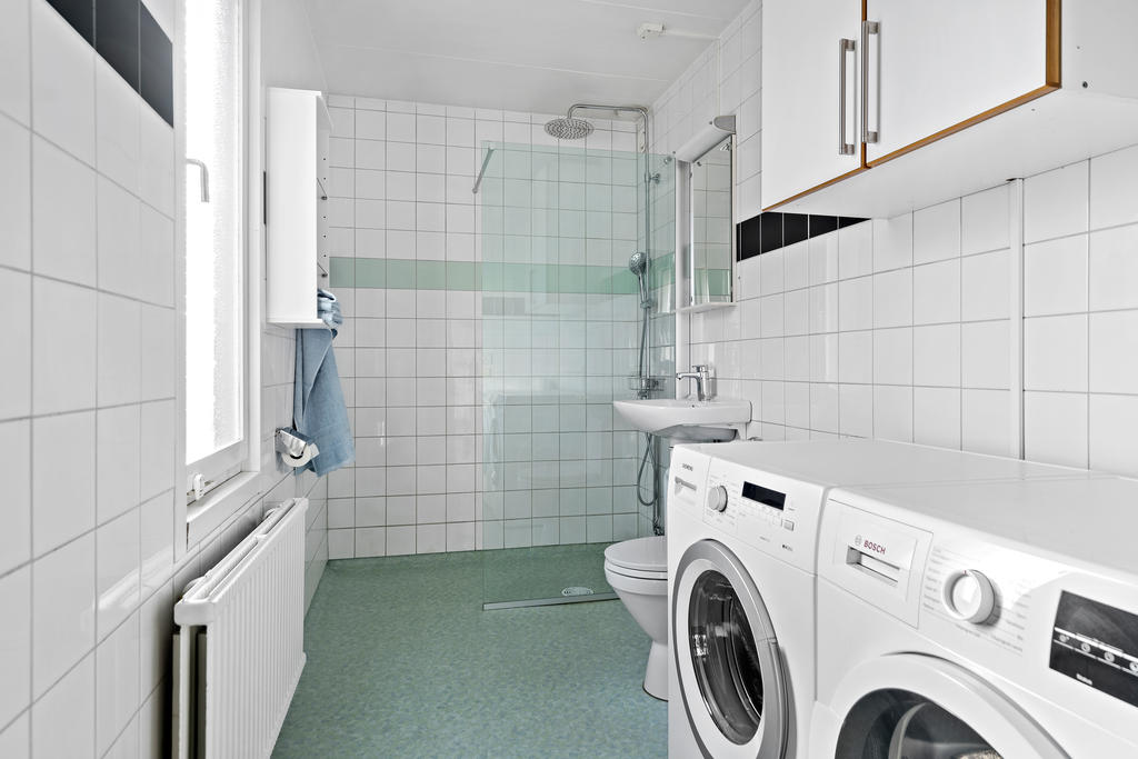 Badrum med tvättmaskin och torkrumlare