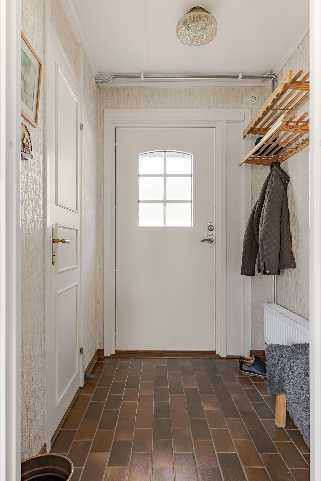 Entréhall med klinkergolv och gästtoalett